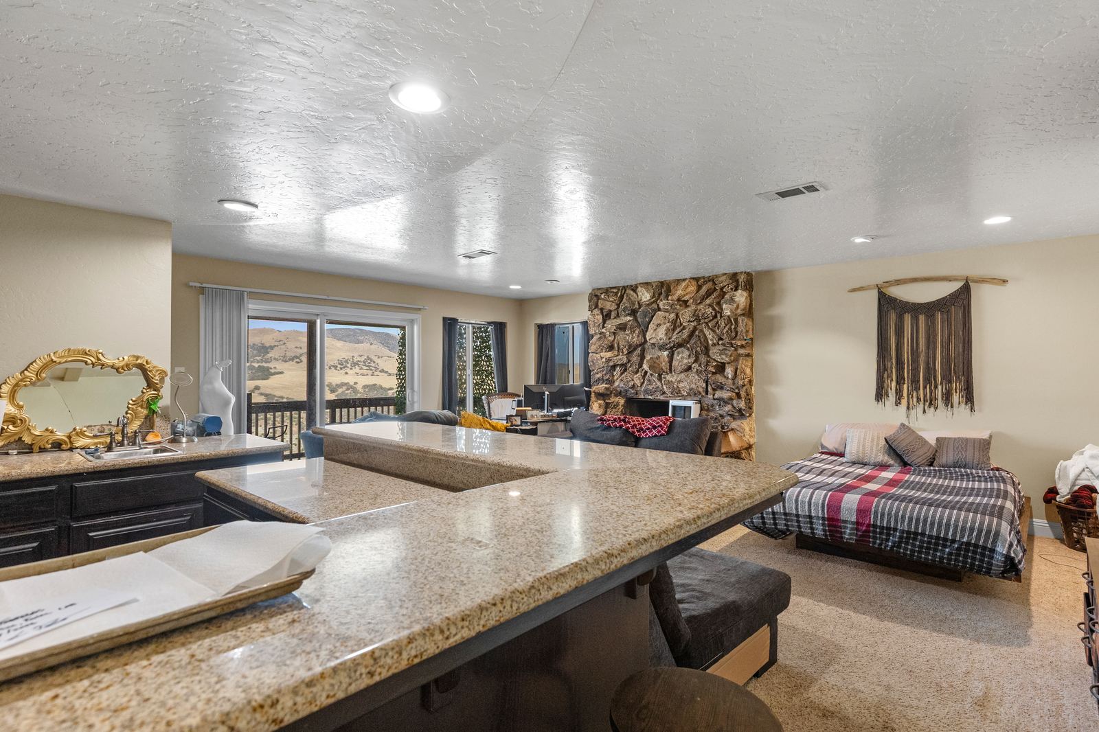 Lower-level family room with granite wet bar, stone fireplace and a slider to the view deck